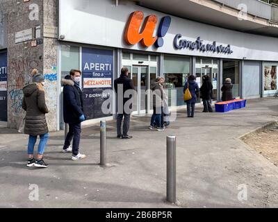 Milan, Italie - 10 mars 2020: Personnes avec masque en file d'attente en dehors du supermarché de la Piazza Damiano Chiesa pendant l'urgence covid-19 coronavirus Banque D'Images