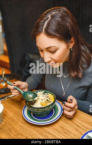 Femme mangeant une soupe de cuisine locale traditionnelle asiatique au restaurant Banque D'Images