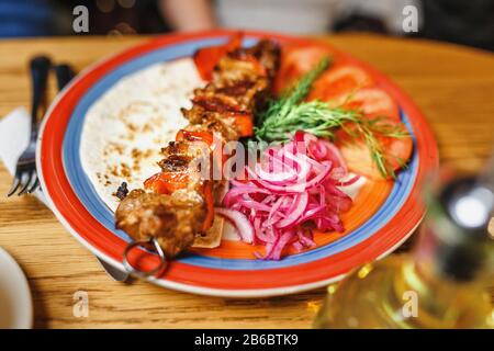 Chichis de viande traditionnelle turque servant des oignons, des tomates et des lavaques sur une assiette au restaurant Banque D'Images