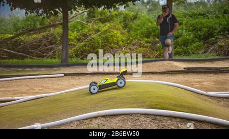 Course de buggy à RC électrique jaune sur une piste extérieure en mousse Banque D'Images