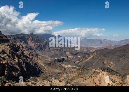 Vue sur la montagne et la vallée le long de la route de Wadi Sahtan dans les montagnes d'Al Hajir entre Nizwa et Mascat en Oman Banque D'Images