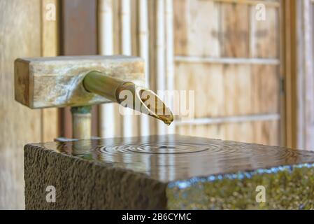 Fontaine de bambou dans la maison de Nomura-ke Samurai à Kanazawa, Japon. Nomurake est une résidence samouraï restaurée avec un beau petit jardin Banque D'Images