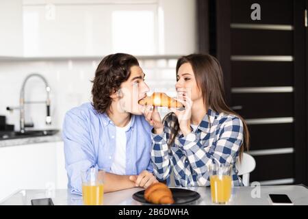 Heureux couple manger le petit déjeuner dans la cuisine Banque D'Images