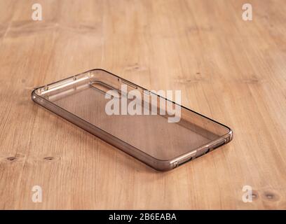 Housse mobile transparente et souple dans une table en bois clair Banque D'Images