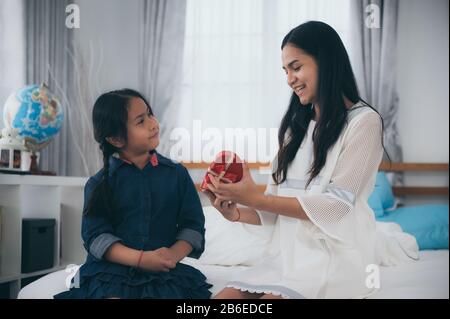 La fille a offert à la mère un cadeau le jour de la Saint-Valentin. Banque D'Images