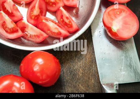 La nourriture. Couteau de cuisine avec tomatos sur le bloc-hache. Banque D'Images