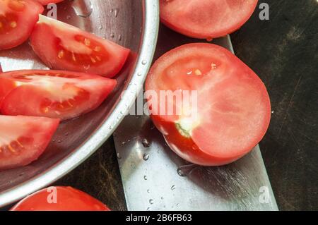 La nourriture. Couteau de cuisine avec tomatos sur le bloc-hache. Banque D'Images