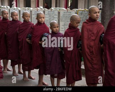 Des moines se sont alignés pour entrer dans la salle à manger pour le premier repas de la journée au monastère de Mahagandayon, Amarapura, région de Mandalay, Myanmar Banque D'Images