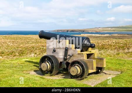 Orkneys, Écosse - 21 juin 2012 : un canon historique noir se dresse dans la zone plus large autour de la colonie néolithique de Skara Brae, dans un pré vert. Banque D'Images