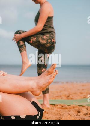 Une femme menant un cours de yoga privé sur la plage En Australie occidentale Banque D'Images