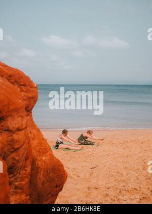 Une femme menant un cours de yoga privé sur la plage En Australie occidentale Banque D'Images