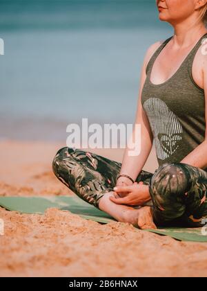 Une femme menant un cours de yoga privé sur la plage En Australie occidentale Banque D'Images