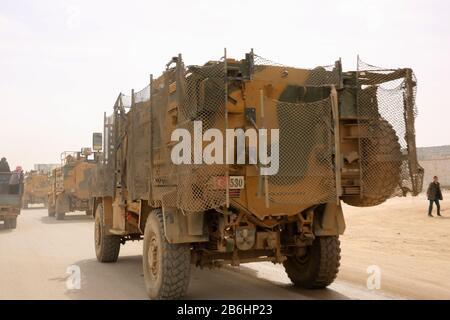 10 mars 2020 : dlib, Syrie. 10 Mars 2020. Un convoi turc de véhicules militaires entre en Syrie par le passage de Kafr Lusin situé près du passage de Bab Al-Hawa dans le nord d'Idlib. La colonne s'est dirigée vers les postes d'observation turcs dans la zone de « remontée électronique » d'Idlib pour renforcer un grand nombre de militaires turcs et de soldats déployés dans la région ces dernières semaines. La Turquie a continué d'envoyer plus de renforcement militaire dans la zone de "remontée électronique" depuis l'entrée en vigueur du nouveau cessez-le-feu dans la région vendredi dernier, à la suite d'une réunion de six heures entre La Présidence russe Banque D'Images