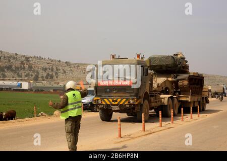 10 mars 2020 : dlib, Syrie. 10 Mars 2020. Un convoi turc de véhicules militaires entre en Syrie par le passage de Kafr Lusin situé près du passage de Bab Al-Hawa dans le nord d'Idlib. La colonne s'est dirigée vers les postes d'observation turcs dans la zone de « remontée électronique » d'Idlib pour renforcer un grand nombre de militaires turcs et de soldats déployés dans la région ces dernières semaines. La Turquie a continué d'envoyer plus de renforcement militaire dans la zone de "remontée électronique" depuis l'entrée en vigueur du nouveau cessez-le-feu dans la région vendredi dernier, à la suite d'une réunion de six heures entre La Présidence russe Banque D'Images