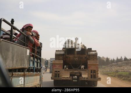 10 mars 2020 : dlib, Syrie. 10 Mars 2020. Un convoi turc de véhicules militaires entre en Syrie par le passage de Kafr Lusin situé près du passage de Bab Al-Hawa dans le nord d'Idlib. La colonne s'est dirigée vers les postes d'observation turcs dans la zone de « remontée électronique » d'Idlib pour renforcer un grand nombre de militaires turcs et de soldats déployés dans la région ces dernières semaines. La Turquie a continué d'envoyer plus de renforcement militaire dans la zone de "remontée électronique" depuis l'entrée en vigueur du nouveau cessez-le-feu dans la région vendredi dernier, à la suite d'une réunion de six heures entre La Présidence russe Banque D'Images