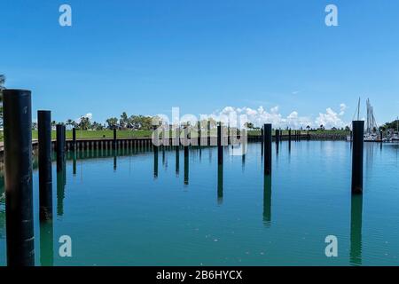 Des postes d'amarrage vides dans une marina à proximité d'un parc et des installations de la ville Banque D'Images