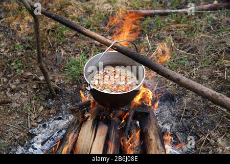 Cuisson de la soupe de légumes dans le chaudron sur feu de camp dans le camp. Nourriture en plein air. La vie dans la nature Banque D'Images