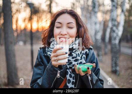 Bonne fille souriante de l'est tenant prendre le café et odeur son arôme Banque D'Images