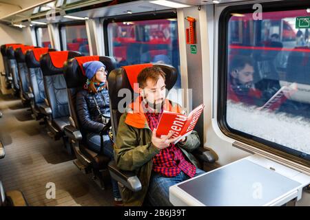 Un homme barbu, voyage dans un train et lit un menu Banque D'Images
