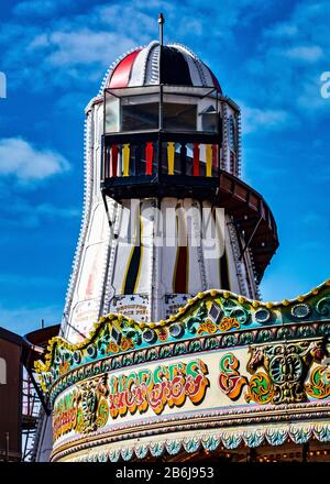 Promenades traditionnelles et anciennes à Helter Skelter et Carousel sur Brighton Pier avec fond bleu ciel Banque D'Images