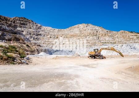 Vue panoramique sur les carrières d'exploitation minière en osite avec pelle hydraulique au travail .exploitation minière de calcaire. Banque D'Images
