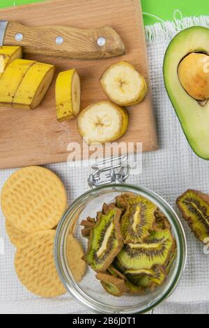 Collation saine. Chips de fruits déshydratés maison sur fond gris. Kiwi sec, banane. Nutrition Banque D'Images