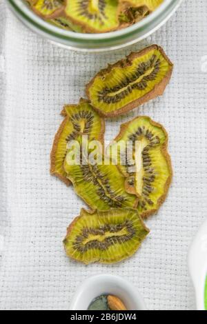 Collation saine. Chips de fruits déshydratés maison sur fond gris. Kiwi sec Banque D'Images