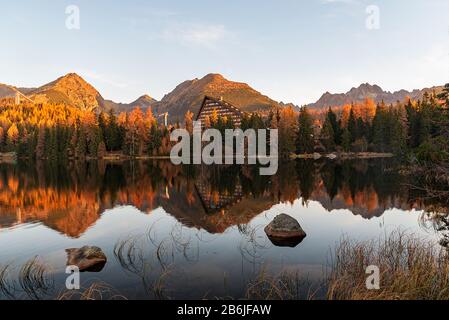 Lac Strbske pleso, forêt colorée et pics sur le fond dans les montagnes Vysoke Tatry en Slovaquie pendant l'automne matin Banque D'Images
