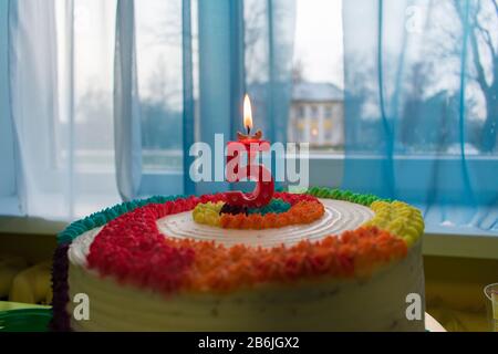 Anniversaire - gâteau coloré anniversaire avec bougie rouge allumée montrant nr. 5 Banque D'Images