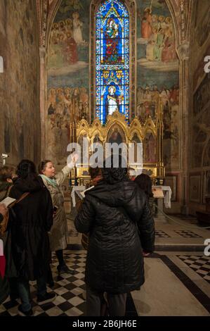 Florence, Italie - 2020, 1er mars : le guide de visite montre les chefs-d'œuvre conservés dans une chapelle de la basilique Santa Maria Novella. Banque D'Images