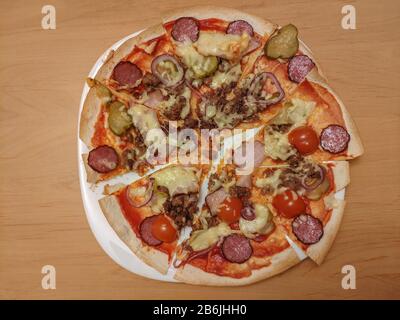 Pizza maison ronde en tranches sur plaque Banque D'Images