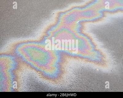 De l'essence colorée déborde sur la rue de l'asphalte Banque D'Images