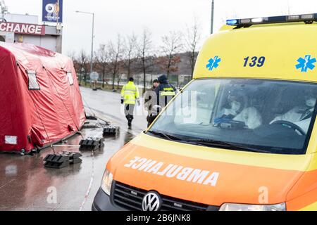 11 mars 2020, République tchèque, Usti Nad Labem: Les employés du service d'ambulance tchèque transportent des personnes dans une ambulance après avoir vérifié des voyageurs à une station-service sur l'autoroute D8 Dresden - Prague. Afin d'empêcher la propagation du virus corona, la République tchèque a entamé des contrôles aléatoires des voyageurs aux frontières de l'Allemagne et de l'Autriche. Photo : Robert Michael/dpa-Zentralbild/dpa Banque D'Images