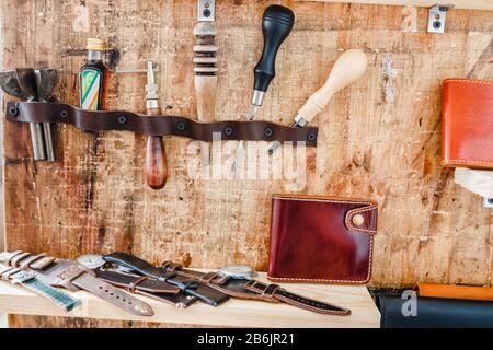 Outils artisanaux en cuir vintage sur fond de bois en magasin Banque D'Images