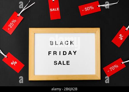 concept commercial et marketing - plateau magnétique blanc avec mots de vente de vendredi noir et étiquettes rouges avec des signes de remise sur fond noir Banque D'Images