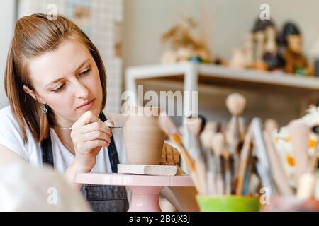 Atelier de céramique de poterie d'argile, femme décorant la vaisselle pot Banque D'Images