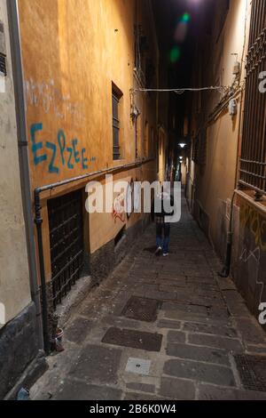 Genova, Italie - 17 janvier 2018: Vue étroite sur la rue de Genova la nuit, l'homme marche en bas de la rue Banque D'Images