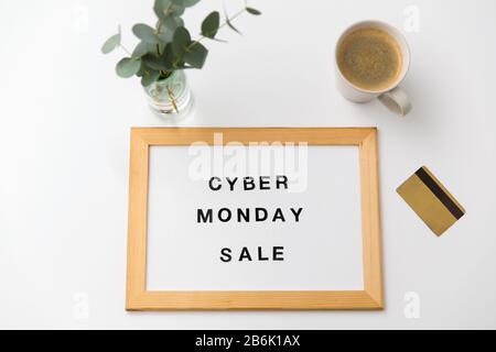 concept de shopping et de marketing - carte magnétique blanche avec les mots de vente cyber lundi, carte de crédit et tasse de café sur la table Banque D'Images