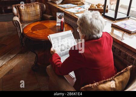 08 juillet 2017, UFA, RUSSIE : une vieille femme lisant un journal dans un café Banque D'Images