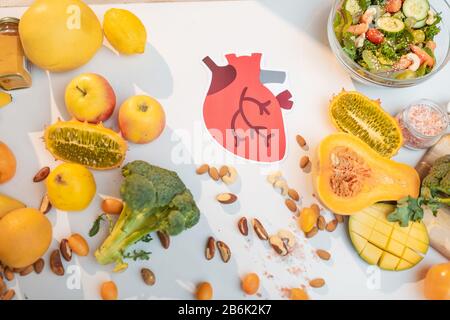Le coeur humain dessine avec une variété de fruits et légumes frais sains sur la table. Concept de nutrition équilibrée pour la santé cardiaque Banque D'Images