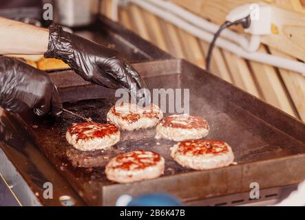 Chef cuisinier cuisine délicieux hamburger de bœuf sur le gril Banque D'Images