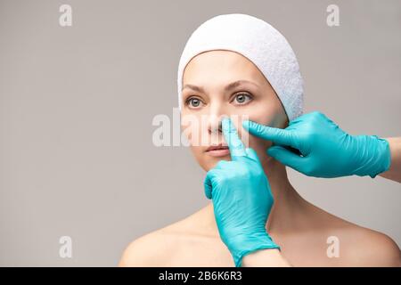 Traitement derma rajeunissement. Chirurgie du visage de cosmologie. Examen anti-rides. Femme et médecin gants mains Banque D'Images