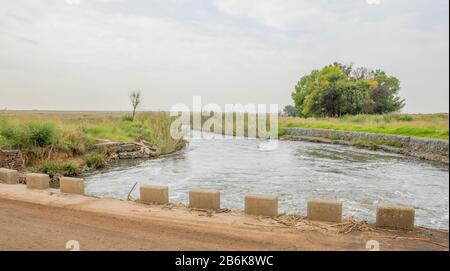 Des murs de retenue de gabion pour contrôler l'érosion et les inondations sur les rives d'une rivière qui coule rapidement Banque D'Images