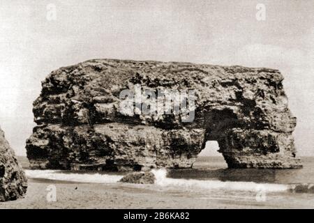 Vers les années 1950 photo montrant Marsden Rock, South Shields , Angleterre comme c'était à l'époque. En raison de l'érosion au fil des ans, l'arche s'est effondrée. Le rocher abrite toujours des colonies d'oiseaux de mer comme les kittiwakes à pattes noires, les fulmars, les goélands et les cormorans Banque D'Images