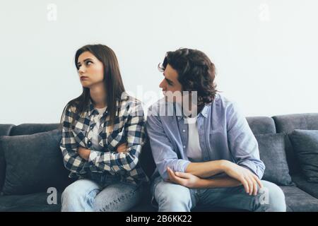 Couple en quart assis sur le canapé dans leur salon Banque D'Images