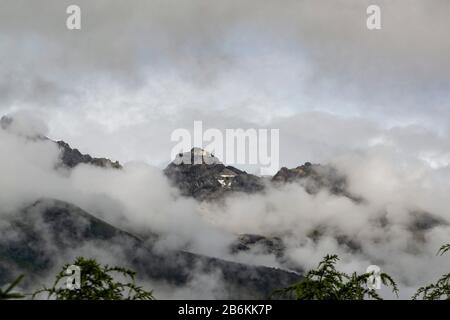 Jade Dragon Snow Mountain, Yulong Xueshan, brisant à travers les nuages et la brume à Lijiang, province du Yunnan, Chine. Les glaciers peuvent être vus toute l'année. Banque D'Images