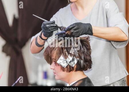 coiffeur colorieuse femme cheveux dans salon de salon de coiffure salon de coiffure, à l'aide de brosse et de feuille, colorant professionnel et concept de traitement Banque D'Images