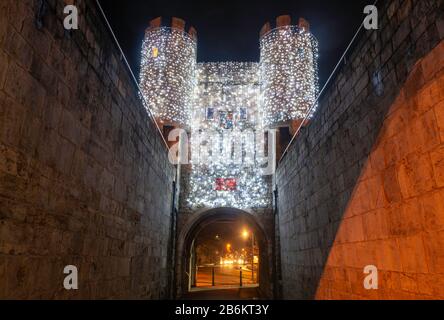 Lumières de Noël sur la tour de Walmgate Bar, York, vu de l'intérieur du barbican Banque D'Images