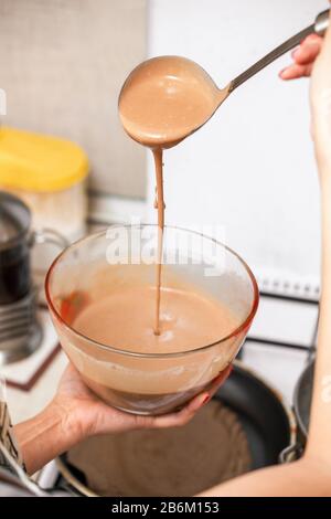 Préparation de pâte à biscuits au chocolat liquide dans un plat de cuisson à la cuisine Banque D'Images