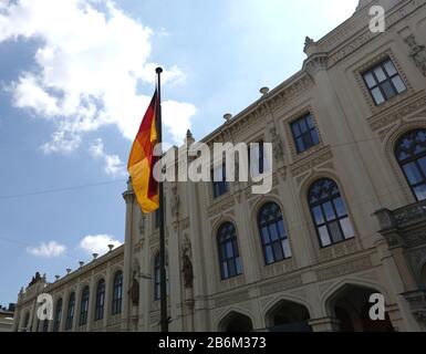 Drapeau allemand sur le flagpole avant la façade du musée Des Cinq Continents à Munich, le jour ensoleillé et lumineux Banque D'Images